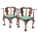 A pair of eastern hardwood corner chairs in George III style, each with a shaped back, solid splat