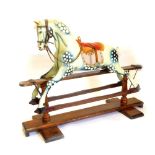 An Ayres type rocking horse, the dapple grey painted horse with velvet and leather padded saddle, on