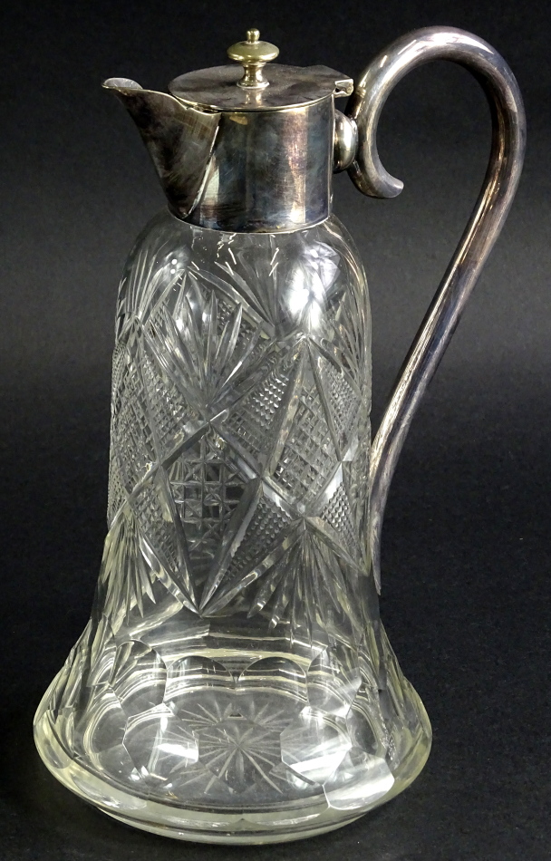 An early 20thC cut glass claret jug, with plated mounts and 'S' scroll handle, the bell shaped