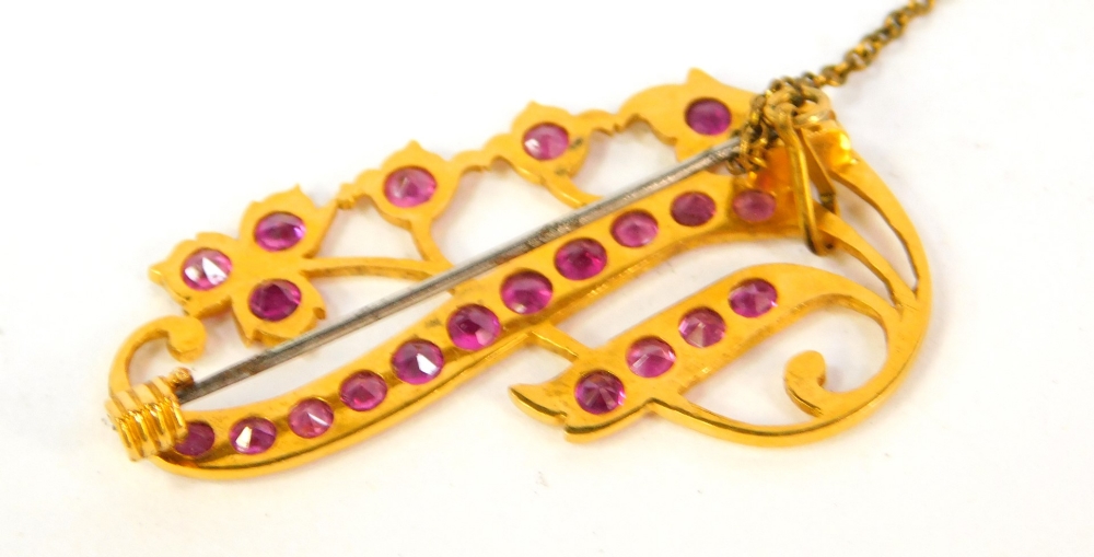 A floral scrolling brooch, with rubies set in a yellow metal mount, 4.5cm wide. - Image 2 of 2