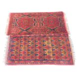 Two similar Persian small rugs or mats, each on a red ground with geometric design, 54cm x 98cm.