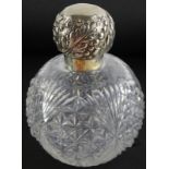 A Victorian cut glass globular scent bottle, with silver mount, embossed with leaves, beads, etc.,