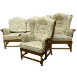 An Ercol light elm cottage type suite, the two seat sofa with shaped arms and fluted frieze, on part