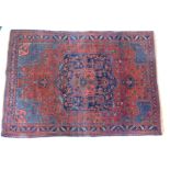A Persian rug, with a central navy blue and red medallion, pale blue spandrels and one wide and