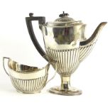 A George V silver urn shaped coffee pot, with part fluted decoration, ebonised knop and handle, on a