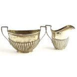 A George V silver part fluted two handled sugar bowl, and a matching milk jug, Birmingham 1910, 4½