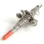 A 19thC silver rattle, with embossed decoration of scrolls, flowers, etc., and with coral teether,