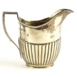 A George V silver part fluted cream jug, with a reeded border and anchored handle, London 1911, 4¾