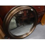 A large modern bronze effect circular convex wall mirror.