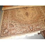 An Indian style machine woven carpet, decorated with flowers, scrolls etc., on a beige ground with