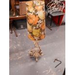 A cream painted wrought iron standard lamp with associated 1960's/70's floral shade.