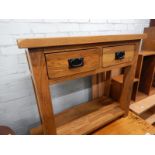 A modern oak side table with two drawers and an undertier.