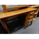 An oak office desk with three drawers.