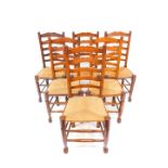 A set of six 19thC oak single ladderback dining chairs, with rush seats, raised on turned legs,