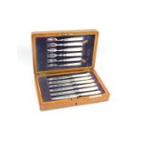 A set of six George V silver fruit knives and forks, with mother of pearl handles, oak cased,