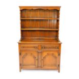 A Thomas Clarkson & Son oak dresser, the two shelf plate rack over two carved drawers over