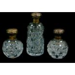 A pair of cut glass scent bottles, with silver mounts and hinged lids, embossed with flowers, 10.5cm