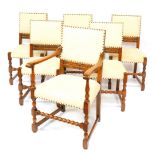 A set of six 17thC style oak dining chairs, with studded over stuffed backs and seats, raised on