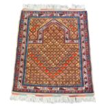 An Afghan prayer rug, the Mihab field filled with repeating floral motifs, against a light brown