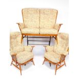 A vintage Ercol light oak three piece cottage suite, upholstered in floral fabric cushions,