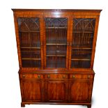 A Georgian style mahogany cupboard bookcase possibly Reprodux, the dentil moulded cornice over three