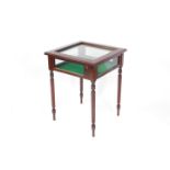 A mahogany bijouterie table, of square section, with bevelled glass top and glass sides, raised on