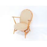 An Ercol 203 light beech and elm Windsor armchair, with loose cushion seat and back, raised on