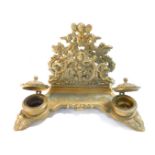 A Victorian style brass desk stand, cast with cherubs, fruit and flowers, with letter rack pen