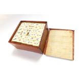 An early 20thC mahogany cased bamboo and bone Mahjong set.