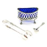 An Edward VII silver oval salt cellar, with blue glass liner, raised on four ball and claw feet,