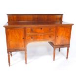 A George IV mahogany and ebony line inlaid sideboard, with splash back, two central drawers