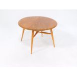 An Ercol 1960's elm drop leaf occasional table, raised on turned ash tripod legs, untied by