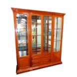 A late 20thC mahogany display cabinet, the outswept pediment over four glazed doors, inset
