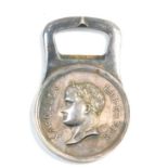 A Christofle Napoleon silver plated bottle opener, obverse a profile of Napoleon Empereur, verso