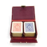 A Patience two pack playing card set, red morocco cased.