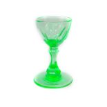 A Victorian uranium green wine glass, the semi fluted bowl raised on a waisted hexagonal stem,