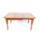 A Victorian mahogany wind out dining table, with one additional leaf, on turned legs, brass capped