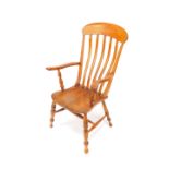 A Victorian oak and elm lath back kitchen chair, raised on turned legs united by an H frame