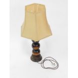A wooden table lamp, formed as four lignum vitae bowls raised on an oak circular base, with shade,