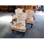 A set of three mahogany coloured 18thC style armchairs, raised on ball and claw feet. The upholstery