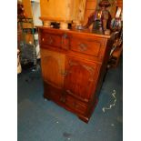 An Old Charm style stained oak television cabinet, 122cm high, 90cm wide, 50cm deep.