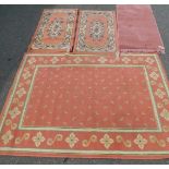 Two pink ground wool rugs, largest 175cm x 126cm, smaller 119cm x 61cm, together with a pair of