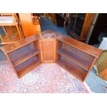 A mid 20thC oak low corner bookcase, with central cupboard, 69cm high, 121cm wide, 108cm deep.