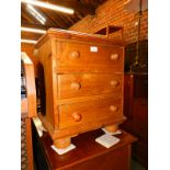 A pine three drawer bedside cabinet, raised on bun feet, 57cm high, 47cm wide, 37cm deep.