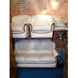 A cream leather three piece suite, with wooden trim to the front, together with a rocking chair. (