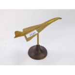 A brass desk stand modelled as Concorde, 18cm wide.