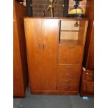 A mid 20thC teak gentleman's wardrobe, enclosing various compartments including a bureau, 154cm