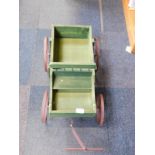 A green painted wooden and metal child's pull-a-long wagon.