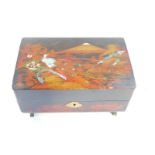 A Japanese lacquered musical jewellery box, with inlaid decoration, 24cm wide.