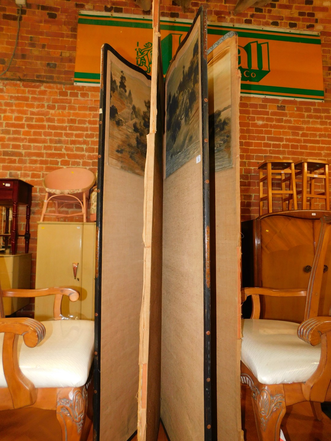 An oriental wooden and fabric four fold screen inset with landscape pictures, 172cm high, 212cm